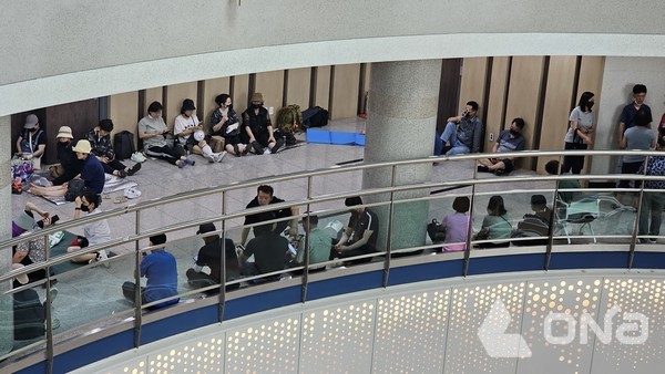 16일 낮 12시 30분께 화성시청 2층 시장실 앞에서 화성남양지역주택조합 서희5차 조합원 60여명이 폭염 속 자리를 지키고 앉아있다.(사진=정양수 기자) ©열린뉴스통신ONA