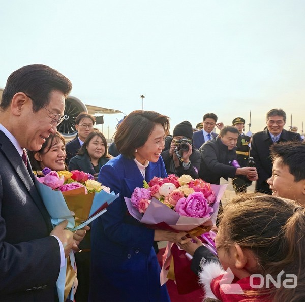 베이징 서우두 공항 도착해 꽃을 전달 받고 있는 이재명 대통령 부부(사진=KTV SNS)©열린뉴스통신ONA